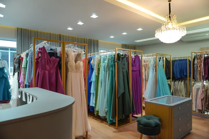 Loja Divina Aluguéis com araras de vestidos de festa e lustre de cristal