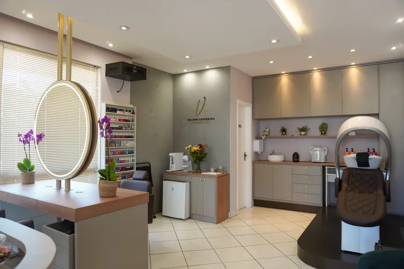 Salão de beleza Valber Cassemiro com espelho circular iluminado e marcenaria cinza
